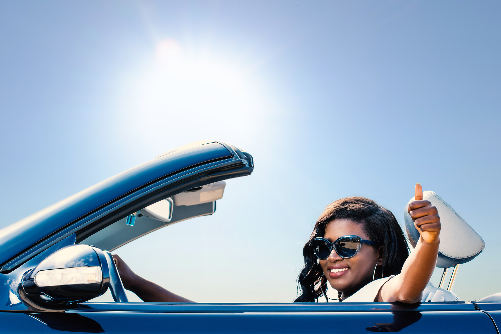 Woman in convertable on sunny day